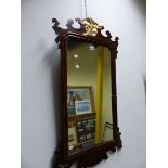 A RECTANGULAR MIRROR IN MAHOGANY CUT WORK FRAME CRESTED BY A GILT EAGLE. 102 x 55cms.