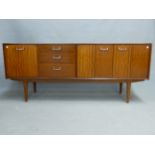 A NATHAN TEAK SIDEBOARD WITH A PAIR OF DOORS AND A COMPARTMENT WITH PULL DOWN DOOR FLANKING THREE