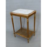 A FRENCH WHITE MARBLE TOPPED GILT WOOD SIDE TABLE WITH A CANED TIER JOINING THE FLUTED LEGS