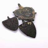 THREE MEDIAEVAL PARCEL GILT BRONZE SHIELD SHAPED PENDANTS, EACH WITH AN ARMORIAL, THE LARGEST OF