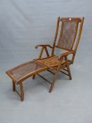 AN ADJUSTING CANED MAHOGANY DECK ARMCHAIR WITH FOOT REST, BRASS LABEL.