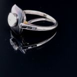 AN ART DECO STYLE DIAMOND AND BLACK ONYX SET 18CT WHITE GOLD RING. THE SINGLE ROUND BRILLIANT CUT TO