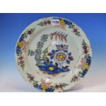 AN 18th C. ENGLISH DELFT POLYCHROME PLATE, THE CENTRAL GARDEN ENCLOSED BY FOUR FLORAL VIGNETTES ON