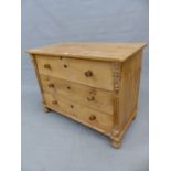 AN ANTIQUE PINE CHEST OF THREE LONG DRAWERS BETWEEN FLUTED PILASTERS AND ON BUN FEET.