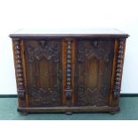 AN OAK BAROQUE STYLE SIDE CABINET, THE DOORS CARVED WITH ANGELS HEADS OVER INLAID STARS