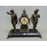 AN ANSONIA CLOCK FLANKED BY TWO SPELTER CAVALIER FIGURES STANDING ON AN IRON PLINTH ON PAW FEET. W