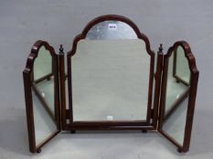 A MAHOGANY TRIPTYCH DRESSING TABLE MIRROR, THE RECTANGULAR FRAMES WITH WAVY ARCH TOPS AND ON KNOB
