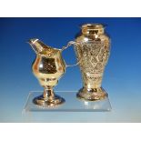 SILVER HELMET JUG MARKS WORN, AND A 900 GRADE EASTERN SILVER REPOUSSE ENGRAVED VASE. HEIGHT 13.5cms.
