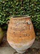 A TERRACOTTA ROMAN URN WITH THREE LUG HANDLES TO THE BELLIED SHAPE, THE RIM. Dia. 51 x H 112cms.