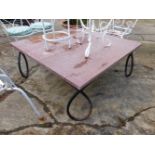 A WROUGHT IRON BASED COFFEE TABLE WITH RED MARBLE TOP.