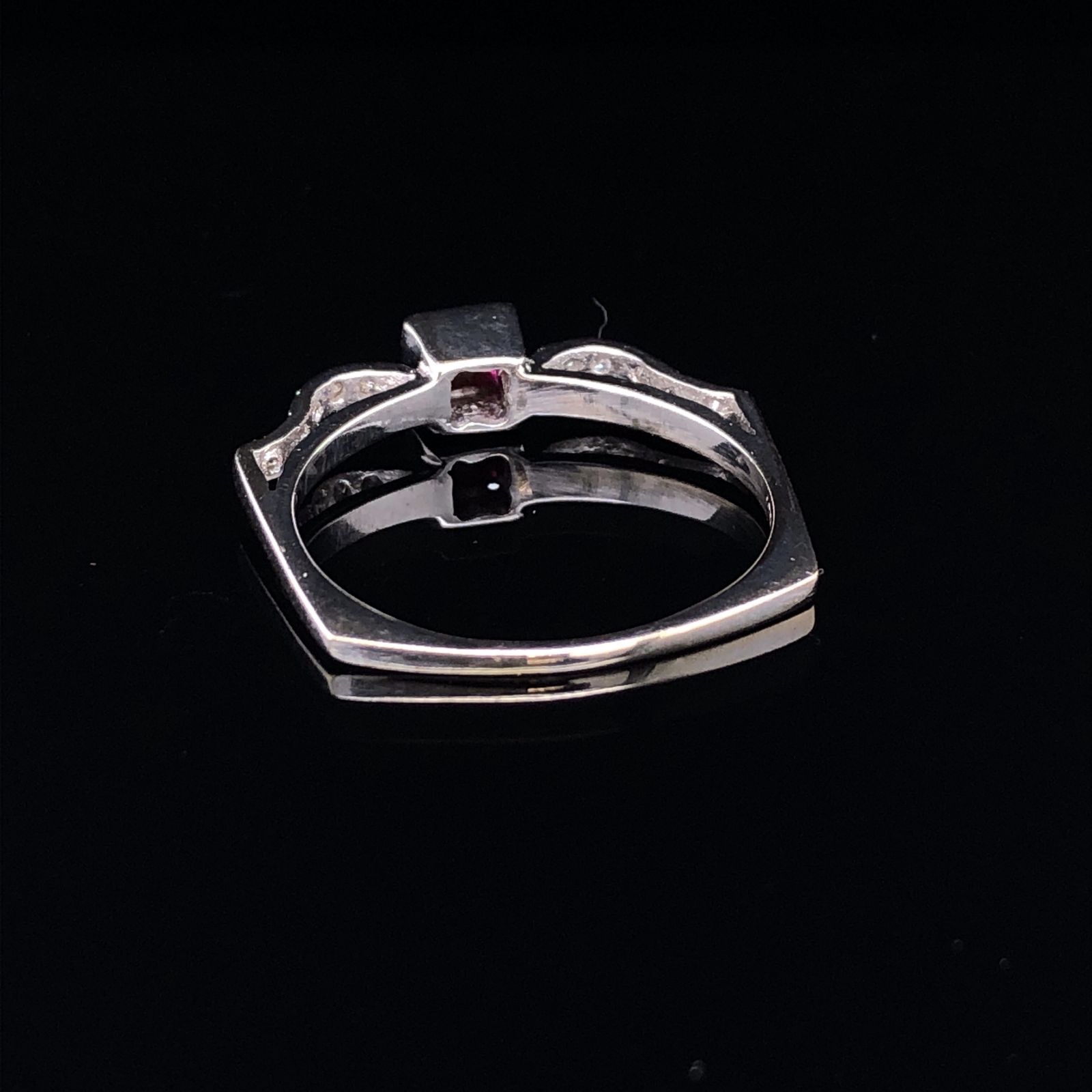 AN 18ct WHITE GOLD UNHALLMARKED RUBY AND DIAMOND RING. THE CENTRAL RUBY PRINCESS CUT IN A RUBOVER - Image 3 of 5