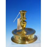A 15th/16th C. BRASS CANDLESTICK THE CYLINDRICAL NOZZLE WITH CANDLE STUB EJECTION HOLE BETWEEN TWO