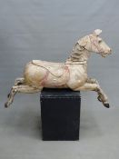 A RARE 19TH CENTURY CARVED WOOD CAROUSEL FIGURE OF A GALLOPING FAIR GROUND HORSE. WITH REMNANTS OF