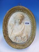 AN EARLY ITALIAN OVAL MARBLE RELIEF OF THE MADONNA DOLEROSA, PROBABLY ROMAN, WITHIN ORIGINAL GILT