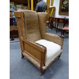A WING ARMCHAIR ON TAPERING SQUARE MAHOGANY FRONT LEGS WITH CASTER FEET