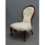 A 19th C. WALNUT SHOW FRAME SIDE CHAIR THE BUTTONED BACK BELOW A CARVED CABOCHON FLANKED BY FOLIAGE,