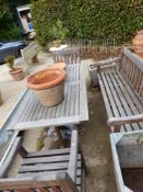 A TEAK GARDEN BENCH AND TWO ARMCHAIRS EACH WITH FLORAL CARVED TOP RAILS TOGETHER WITH A TEAK TABLE