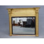 A 19th C. RECTANGULAR MIRROR WITHIN REEDED EBONY SLIP FLANKED BY GILT FLOWER HEAD TOPPED RING TURNED