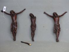 THREE MAHOGANY STAINED PINE FIGURES OF CHRIST CRUCIFIED. H 50cms.