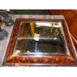 AN EARLY BEVELLED GLASS RECTANGULAR MIRROR IN A CUSHION SHAPED MAHOGANY FRAME MARQUETRIED WITH SATIN