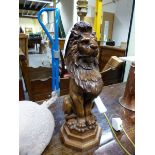 A TABLE LAMP WITH RED SHADE, THE BASE AS A LION SEATED ON A STEPPED OCTAGONAL BASE.