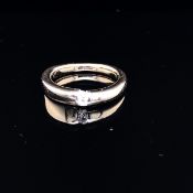 AN 18ct WHITE AND YELLOW GOLD UNHALLMARKED DIAMOND WAVE RING. THE BRILLIANT CUT DIAMOND IN A BAR