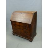 A GEORGE III OAK BUREAU, THE FALL AND FOUR GRADED DRAWERS WITH MAHOGANY BANDING ABOVE BRACKET