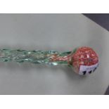 A SPIRAL TWIST GLASS WALKING CANE FILLED WITH COLOURED HUNDREDS AND THOUSANDS. H 116cms.