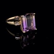 A 10ct GOLD AMERTRINE AND DIAMOND COCKTAIL STYLE RING. THE EMERALD CUT STONE IN A FOUR CLAW CORNER