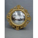 A SHALLOW CONVEX MIRROR IN A GILT GESSO FRAME PIERCED AND CAST WITH SCROLLS AND FOLIAGE. Dia.