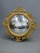 A SHALLOW CONVEX MIRROR IN A GILT GESSO FRAME PIERCED AND CAST WITH SCROLLS AND FOLIAGE. Dia.