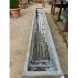 A LONG GALVANISED TROUGH.