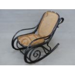 A THONET STYLE EBONISED BENT WOOD ROCKING CHAIR WITH CANED BACK AND SEAT