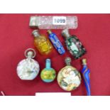 A COLLECTION OF SIX GLASS AND TWO PORCELAIN SCENT BOTTLES, SOME WITH WHITE METAL COVERS, ONE