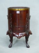 AN ANTIQUE MAHOGANY KETTLE STAND WITH METAL LINER, THE CYLINDRICAL BODY CARVED WITH FOLIAGE RELIEFS