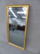 AN ANTIQUE GILT BEVELLED GLASS RECTANGULAR MIRROR WITHIN A GILT FRAME WITH BEADED BAND.