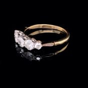 A FIVE STONE GRADUATED DIAMOND RING, IN A WHITE SETTING ON A 15ct YELLOW GOLD UNHALLMARKED SHANK.