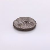 A SILVER COIN WITH THE HEAD OF NERO ON ONE SIDE AND AN EAGLE ON THE REVERSE