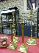 A PAIR OF EARLY 19th C. BRASS SQUARE BASE FLUTED COLUMN CANDLESTICKS. H 29cms. ANOTHER PAIR LATER