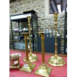 A PAIR OF EARLY 19th C. BRASS SQUARE BASE FLUTED COLUMN CANDLESTICKS. H 29cms. ANOTHER PAIR LATER