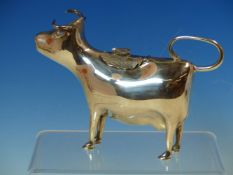 A SILVER HALLMARKED COW FORM CREAMER, THE BODY OF THE COW WITH A HINGED FLORAL COVER AND RESTING