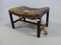 A GEORGE III MAHOGANY STOOL, THE LEATHER COVERED BOWED SEAT ON SQUARE SECTIONED LEGS JOINED BY AN