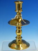 A MID 17th C. BRASS CANDLESTICK, THE NOZZLE WITH CANDLE STUB EJECTION HOLE AND BALUSTER COLUMN,