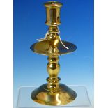 A MID 17th C. BRASS CANDLESTICK, THE NOZZLE WITH CANDLE STUB EJECTION HOLE AND BALUSTER COLUMN,