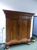 AN EARLY CONTINENTAL WALNUT BAROQUE STYLE ARMOIRE OF HEAVY CONSTRUCTION WITH MOULDED CORNICE, TWIN P