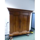 AN EARLY CONTINENTAL WALNUT BAROQUE STYLE ARMOIRE OF HEAVY CONSTRUCTION WITH MOULDED CORNICE, TWIN P