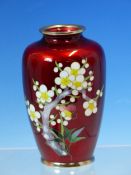 ATTRIBUTED TO ANDO JUBEI, A RED GROUND CLOISONNE VASE WORKED ON ONE SIDE WITH A BRANCH OF PLUM