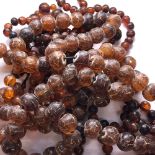 A CONTINUOUS ROW OF ANTIQUE IRREGULAR AMBER BEADS, POSSIBLY CHINESE. APPROX SIZE OF LARGEST BEAD