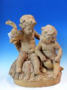 A 19th C. FRENCH TERRACOTTA GROUP OF TWO NAKED CHILDREN IN DISCUSSION WHILE SEATED ON A