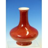 A CHINESE COPPER RED BOTTLE VASE, THE SLENDER NECK ABOVE A COMPRESSED SPHERICAL BODY, SIX
